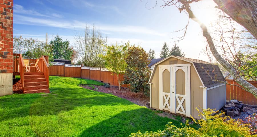 Fenced backyard with storage shed in Logan